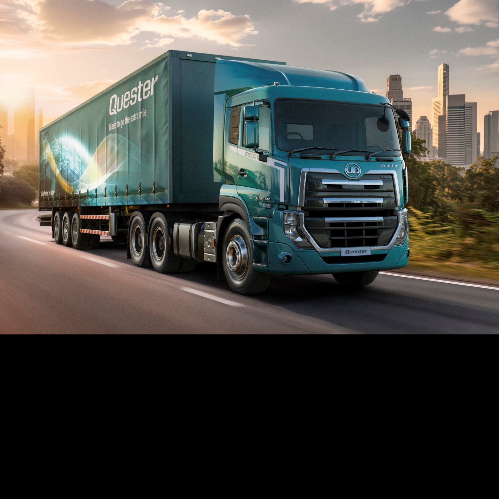 Lori kubwa ya bluu inaenda mjini kwenye barabara yenye miti na jua linachomoza.