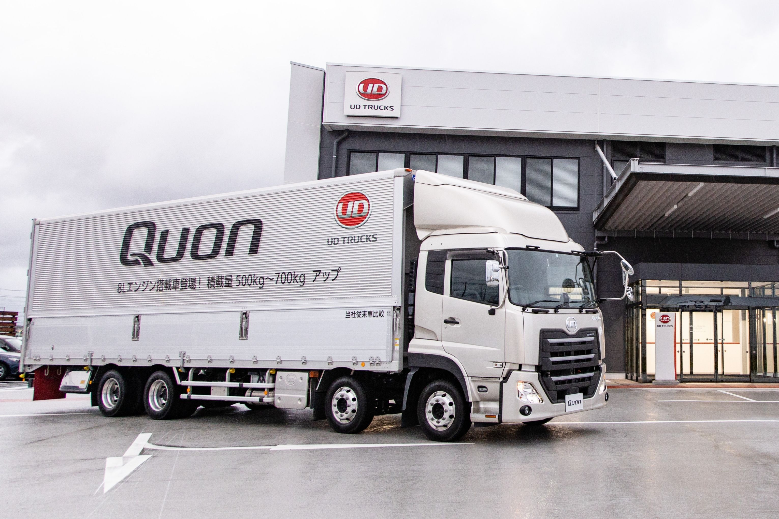 白い大型トラックがビルの前に停車している