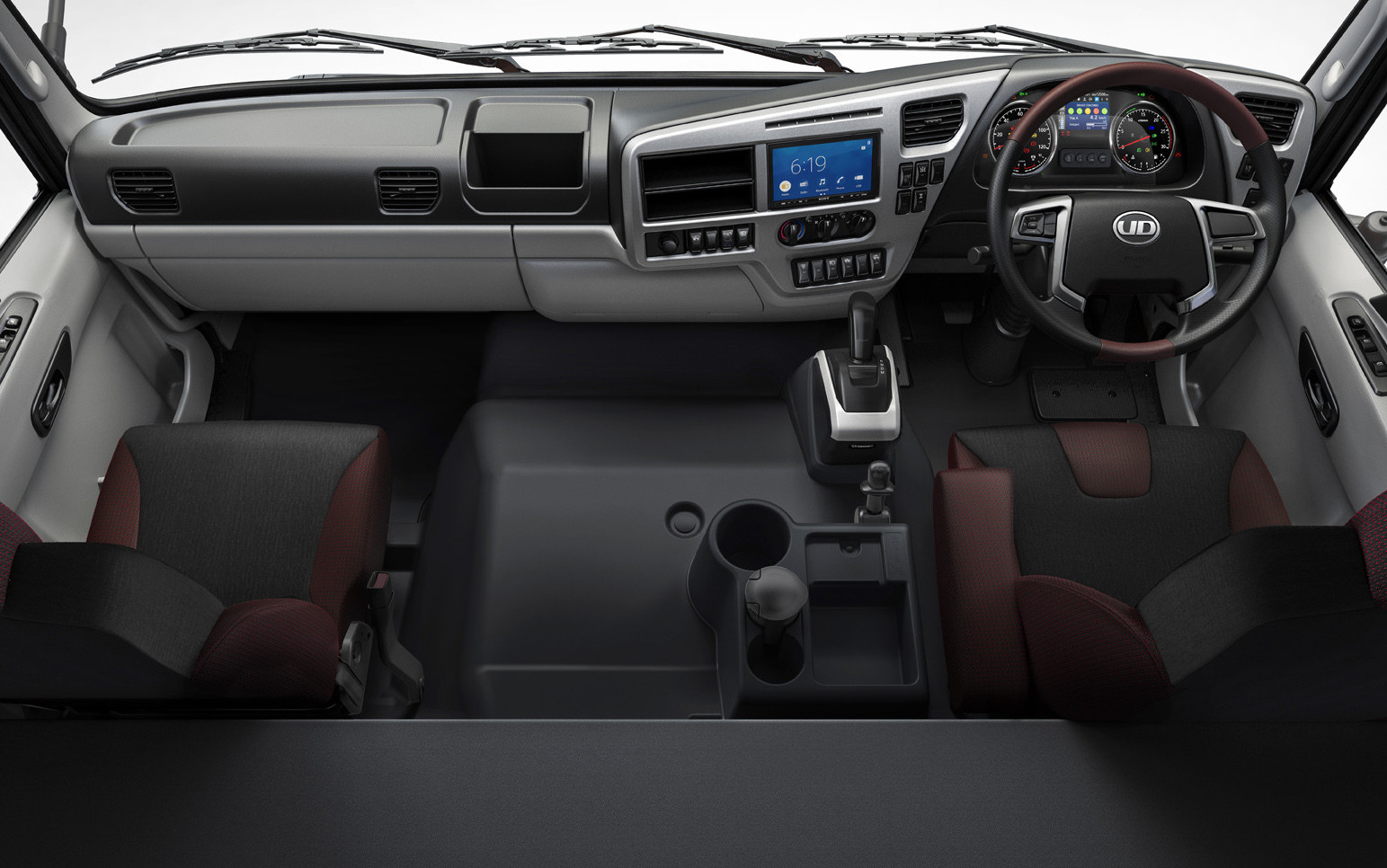 Modern truck cabin interior with two seats, steering wheel, and dashboard controls.