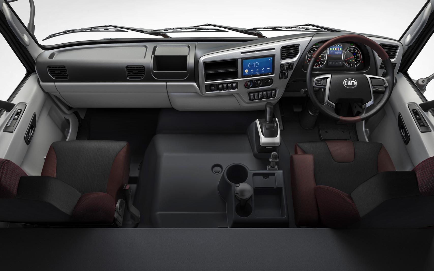 ภายในห้องโดยสารรถบรรทุกสีเทา แผงหน้าปัดและพวงมาลัยด้านขวา