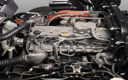 Diesel engine with cables, pipes, and metal components in a vehicle chassis