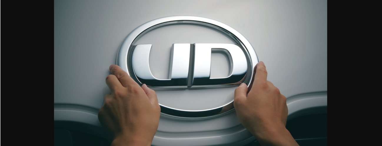 両手でUDトラックスのロゴを触っている車のボンネット