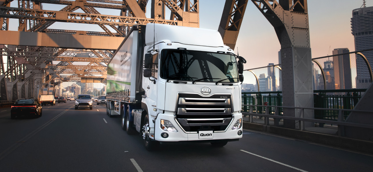 Wit vragmotor ry oor 'n stadsbrug by sonsopkoms.